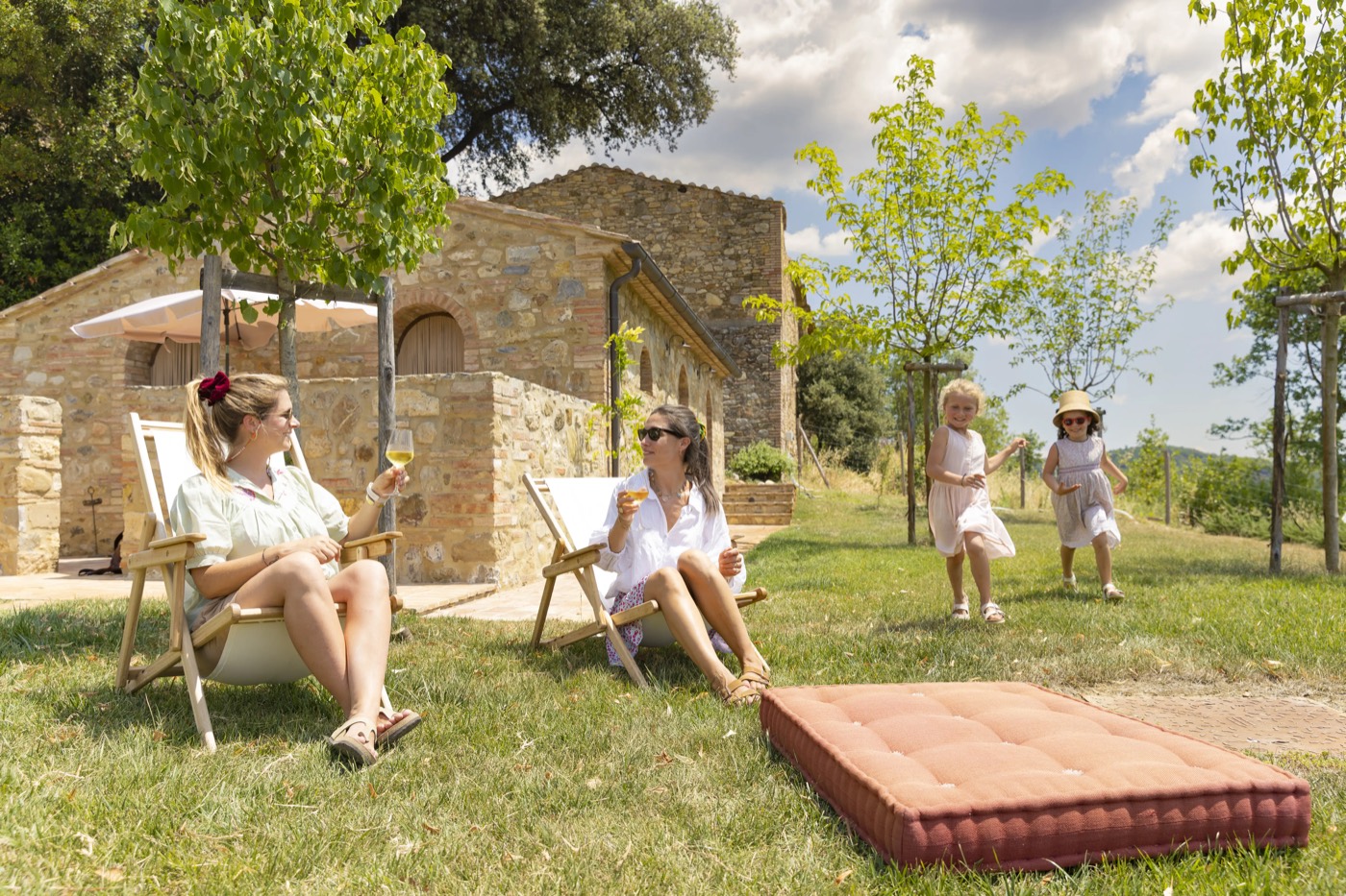 Famiglia in relax sul prato davanti al Podere Capannina, con un brindisi