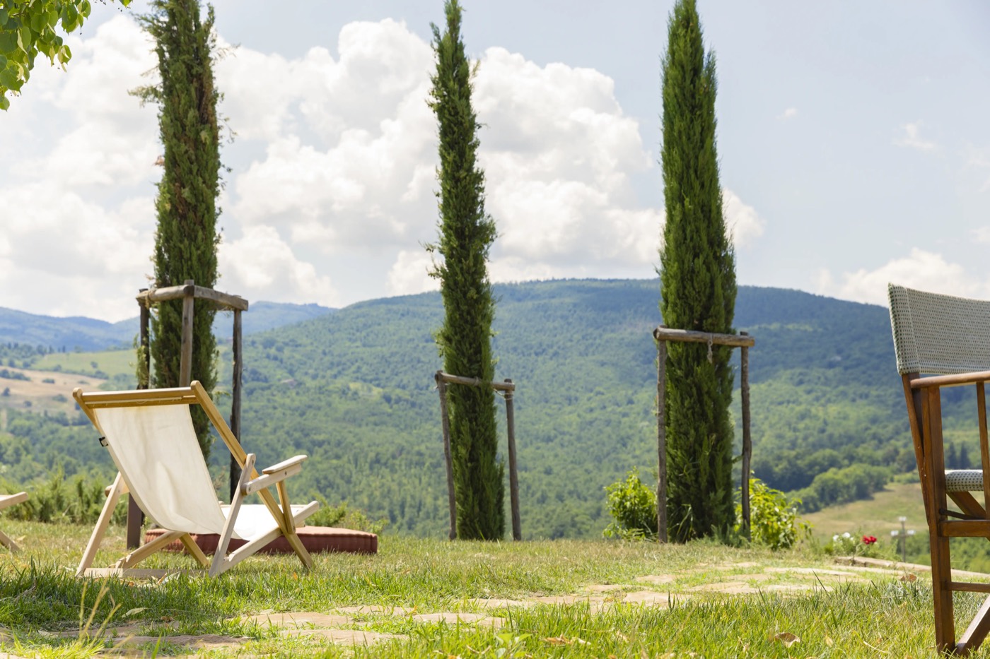 Sedia da regista tra i cipressi del Podere Capannina, affacciata sulla valle