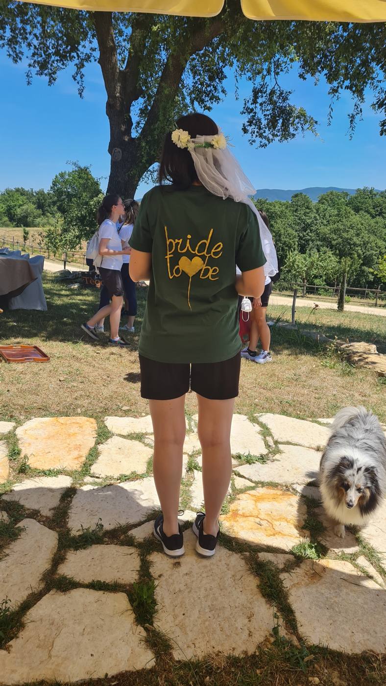 La festeggiata con maglietta 'bride to be', velo e corona di fiori, in fattoria