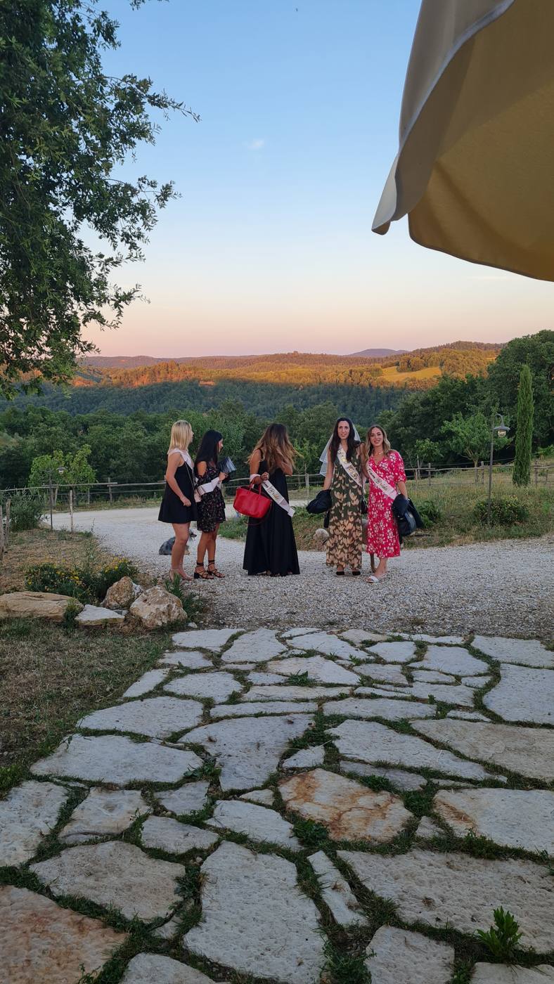 Il gruppo con le fasce 'Team Bride' al tramonto sulle colline toscane