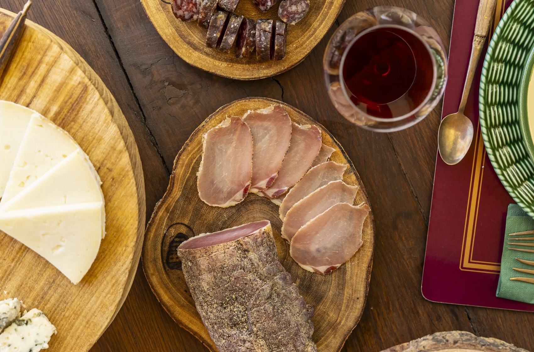Tagliere di salumi, formaggi e olio con calici di vino sulla tavola imbandita della fattoria
