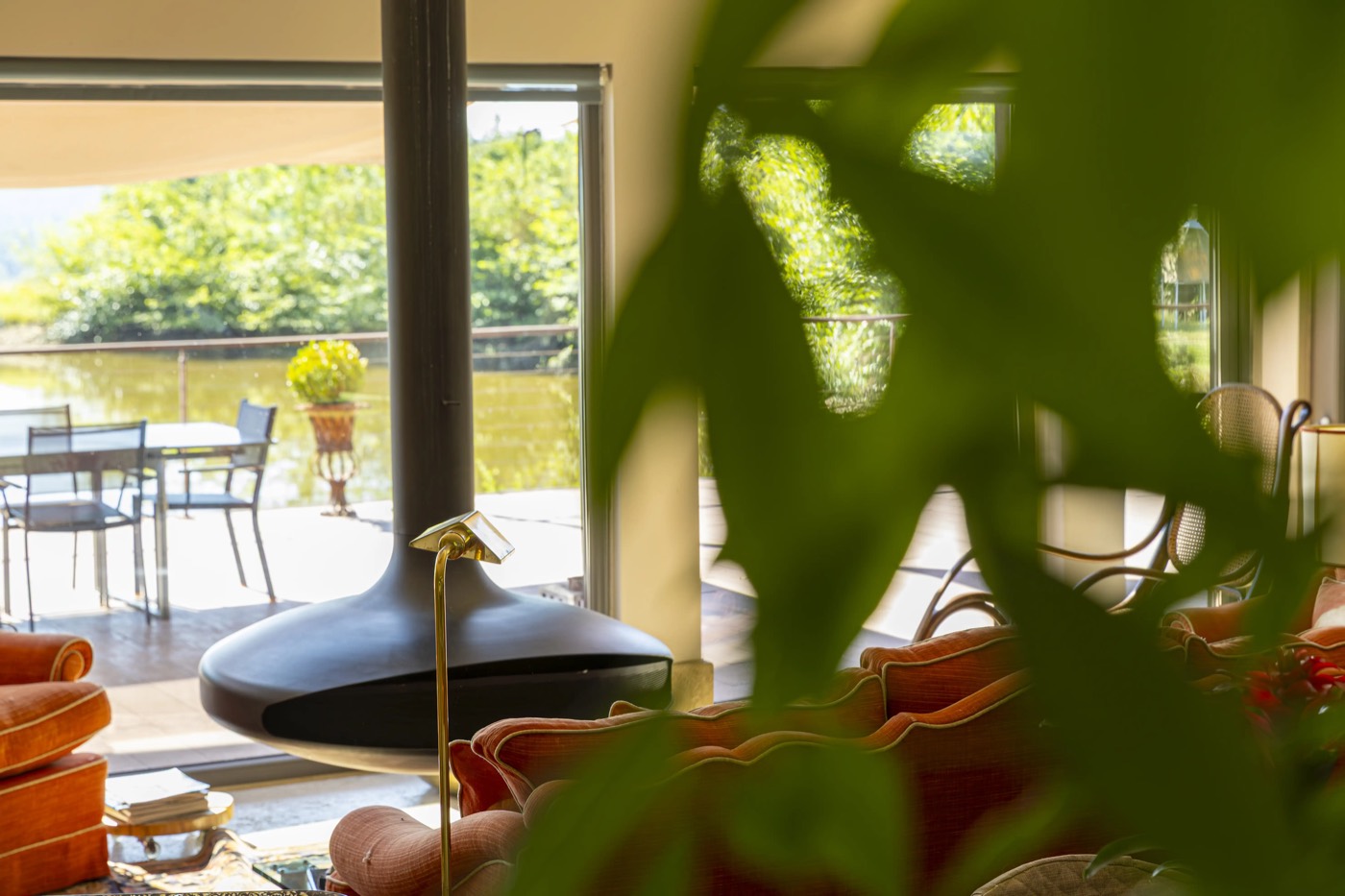 Il salotto di Villa Airone con camino sospeso, affacciato sulla terrazza e il verde